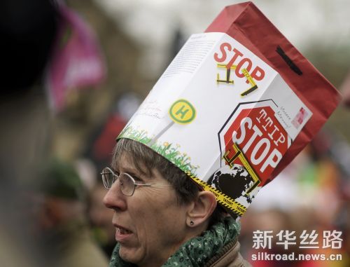 4月23日，在德国汉诺威市，一名女子戴着写有反对TTIP标语的帽子参加游行。