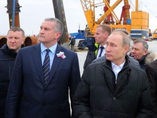 普京（前右）在克里米亚总理阿克肖诺夫（前左）的陪同下视察跨海大桥建设工地。