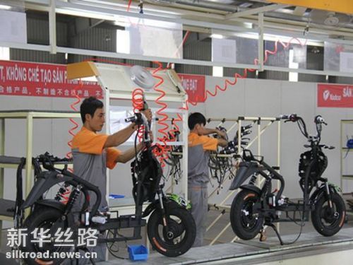 图为在越南首都河内，工人在雅迪电动车工厂内组装电动车