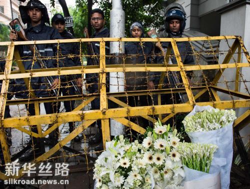 7月3日，在孟加拉国首都达卡，通往遇袭餐厅道路的哨卡处摆放着鲜花