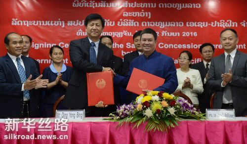 9月2日，在老挝首都万象，老挝亚太卫星有限公司总经理丁咏冰（前左二）与老挝计划投资部副部长本塔维·西苏潘通（前右二）在代表中老双方签约后握手 新华社发（刘艾伦摄）