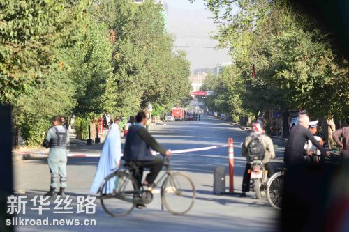 图为当地时间6日上午阿富汗安全人员在爆炸发生后封锁现场道路　记者代贺摄