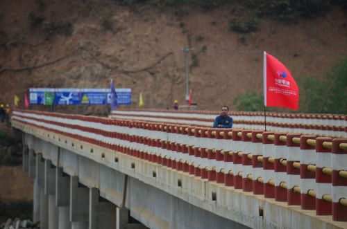 12月12日，在老挝琅勃拉邦，一名工作人员从中国公司修建的桥上走过。
