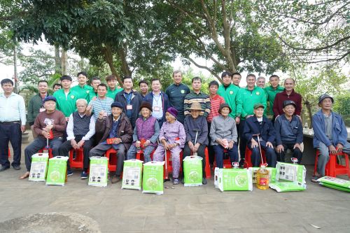 老城经济开发区管委会主任王世雄、老城镇委书记陈家壮及北京国安足球队成员与罗驿村长寿老人合影。曾文君 摄