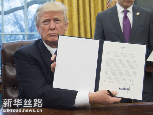 图为1月23日，美国总统特朗普展示自己签署的行政命令。