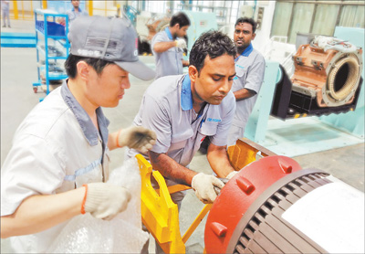 2016年8月中国中车南亚地区首个铁路工厂在印度投产。图为印度哈里亚纳邦巴沃工业园区中车铁路工厂生产线上的中印工人。本报记者 苑基荣摄