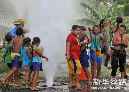 2月16日，在库克群岛拉罗汤加岛举行的供水项目交接仪式上，当地儿童在水柱中嬉戏。    新华社记者宿亮摄