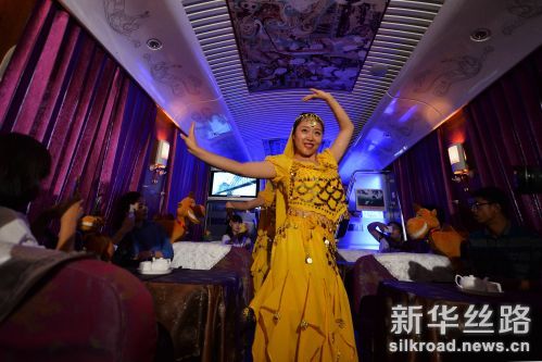 兰州铁路局“敦煌号”列车的列车员身穿敦煌元素的服饰为旅客表演敦煌舞蹈。（2016年7月12日摄）