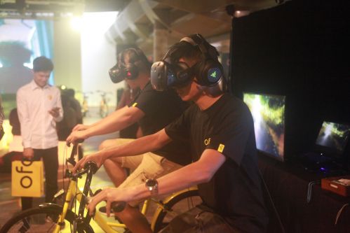 两名ofo工作人员在演示用虚拟现实技术感受骑行乐趣