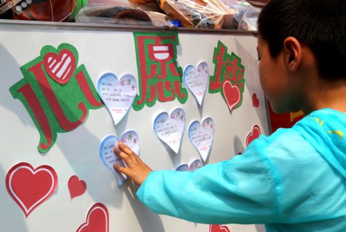 孩子在心愿墙上贴上自己的小心愿。（资料图片）