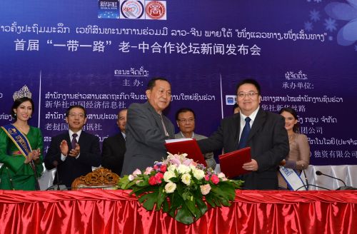 新华社中国经济信息社董事、副总裁匡乐成（前排右）与老挝国家通讯社社长顺通（前排左），签署代理合作协议。