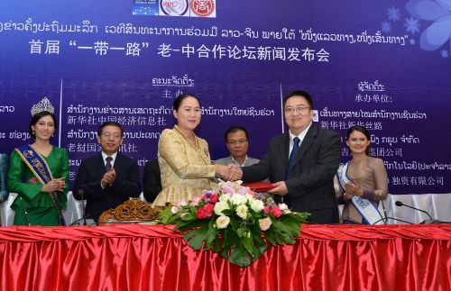 新华社中国经济信息社董事、副总裁匡乐成（前排右）与老挝吉达蓬集团有限公司总经理沃拉泰·桑提孔卡签署代理合作协议。