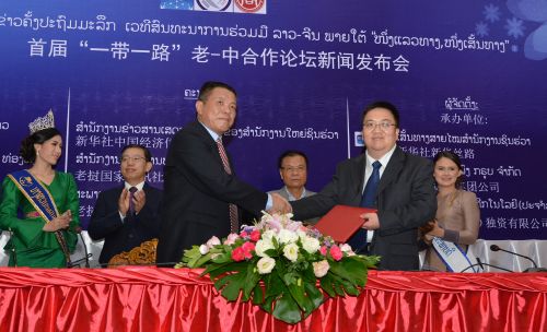 新华社中国经济信息社董事、副总裁匡乐成（前排右）与中国电建老挝南欧江发电有限公司总经理黄彦德签署合作协议。