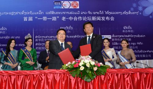 新华社中国经济信息社董事、副总裁匡乐成（前排左）与老挝亚太总经理黄彦德签署合作协有限公司总经理丁咏冰签署合作协议。