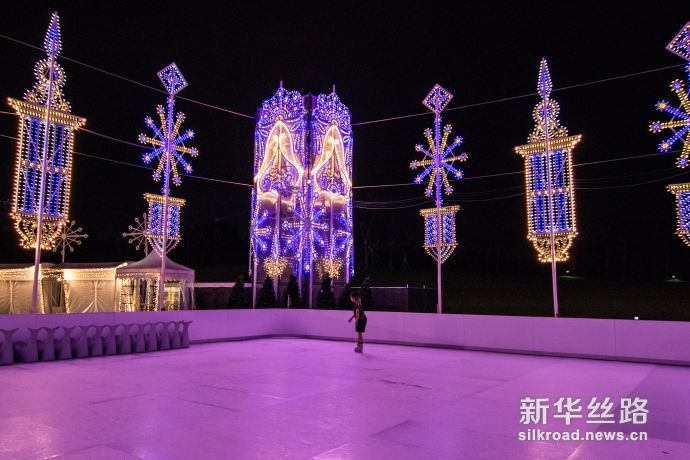 图1 游客经过通往“圣诞仙境”主场地的圣诞灯饰走廊（新华社发 符传威摄）