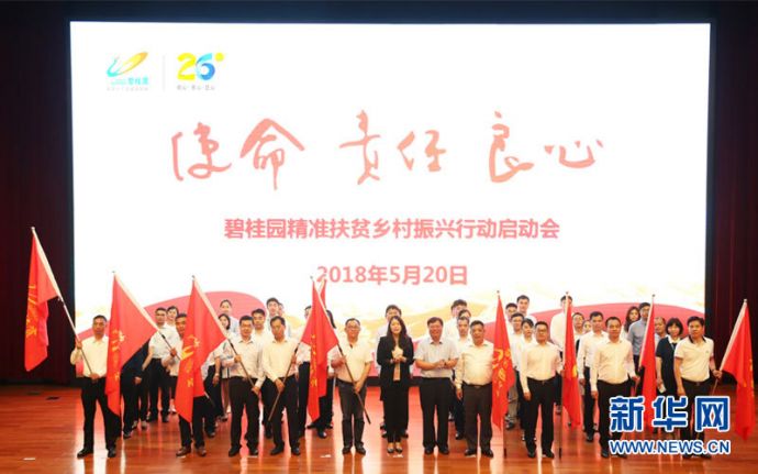 碧桂园董事局副主席杨惠妍（前排左6）、碧桂园集团总裁莫斌（前排左7）为碧桂园扶贫团队授旗。新华网发