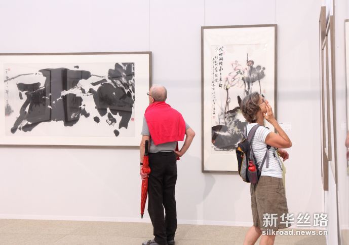 6月2日，2名参观者在敦煌馆里欣赏艺术作品。