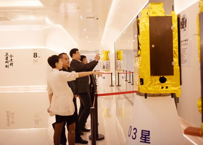 参会人员参观航天科普教育基地展示的卫星