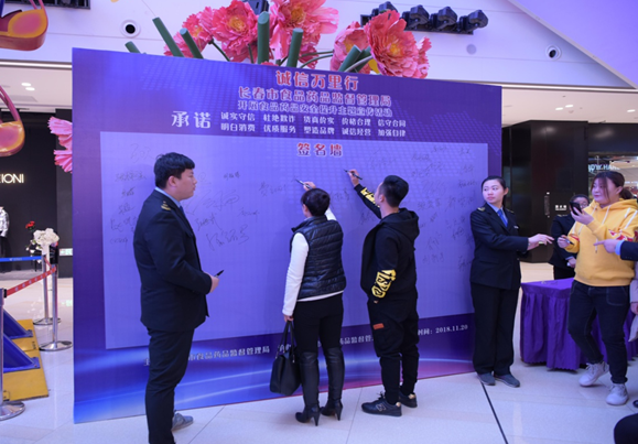 商户代表在承诺签字板上签署诚信经营承诺