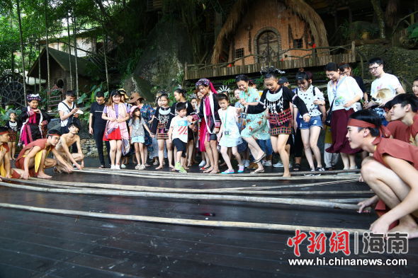 游客在保亭槟榔谷景区跳起欢快的黎族打柴舞