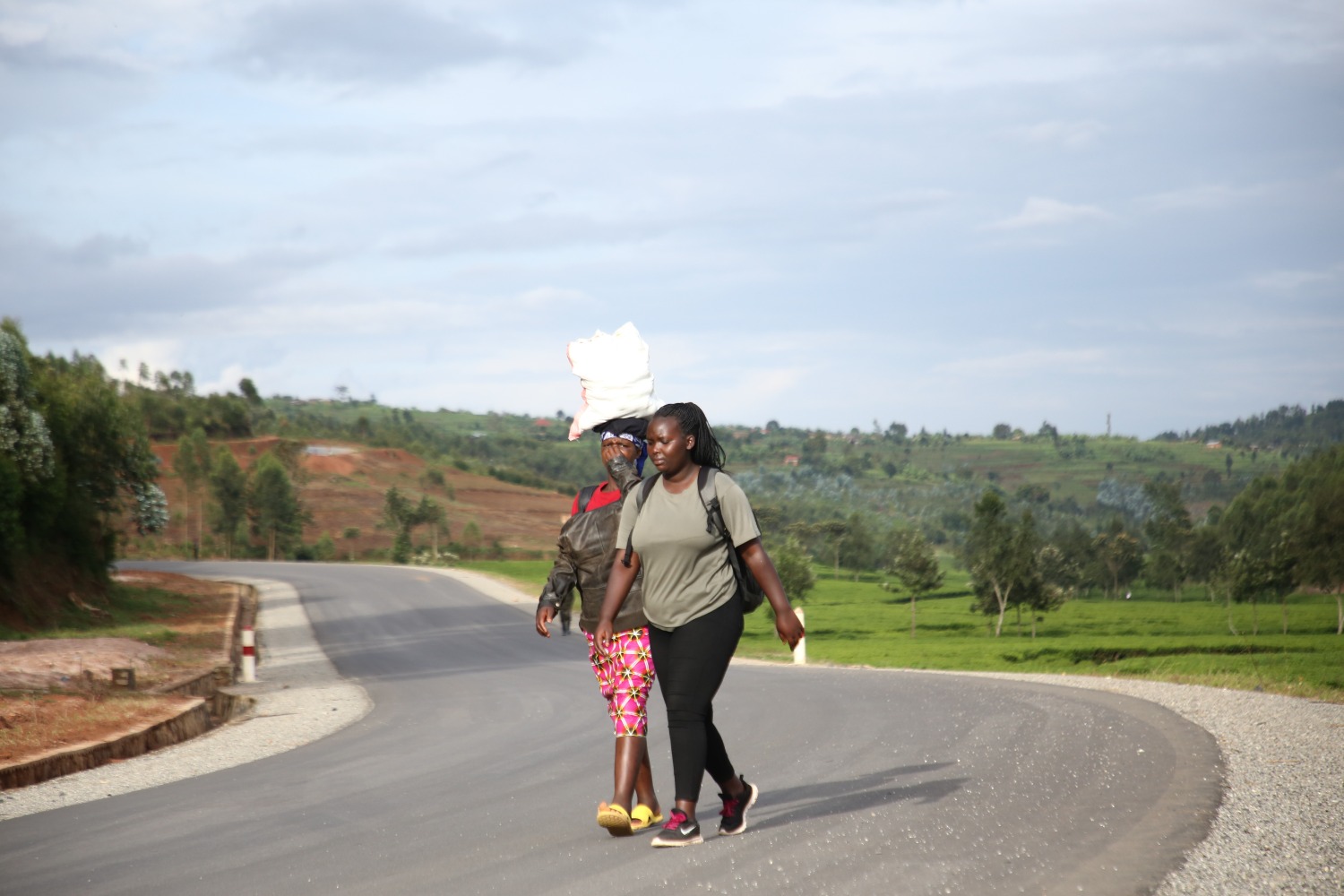4月21日，两名女子行走在卢旺达胡耶市通向基贝霍镇的公路上。.jpg