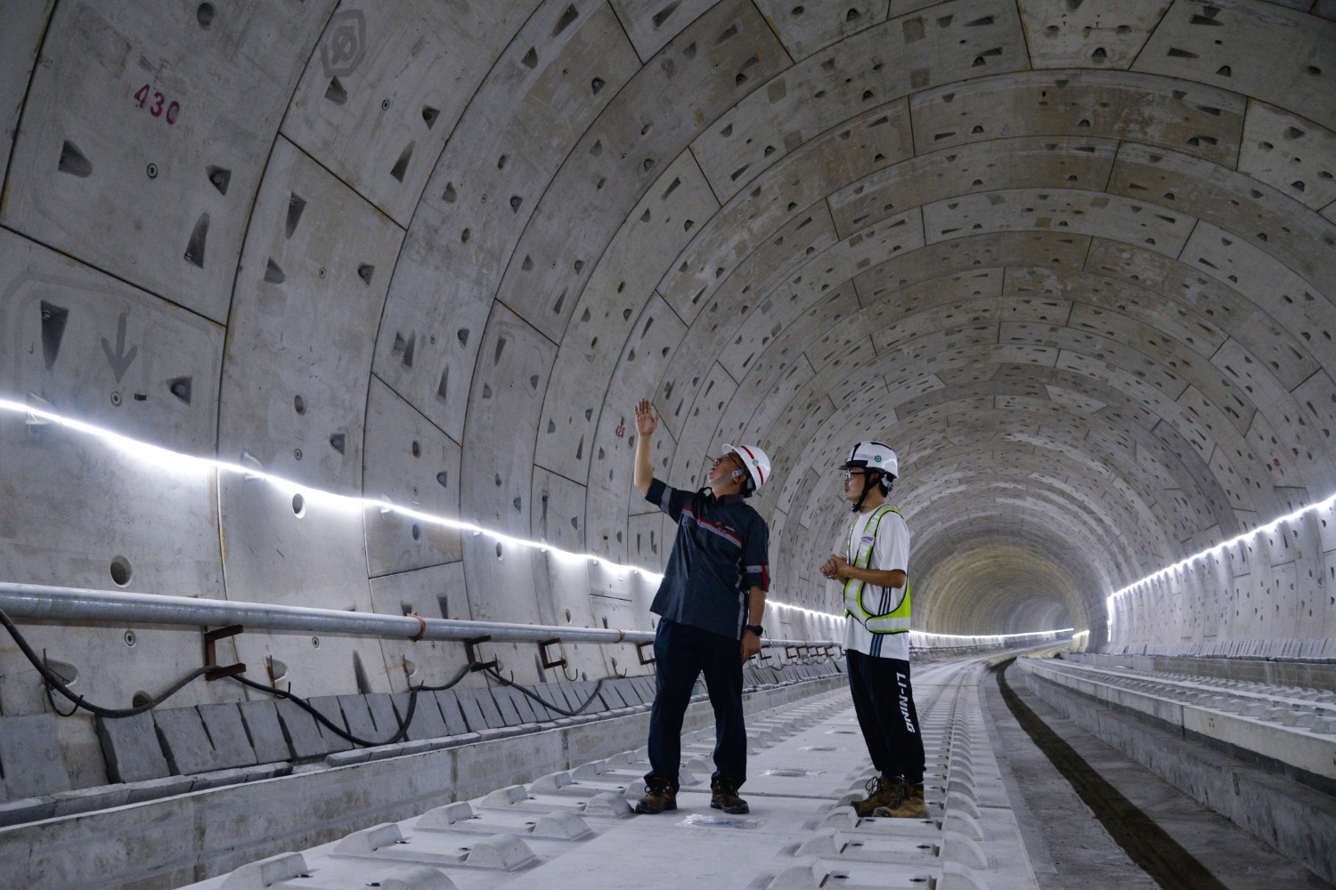 5月9日，印尼中国高速铁路有限公司财务董事张超（左）和同事在印度尼西亚雅万高铁1号隧道内查看施工情况。.jpg